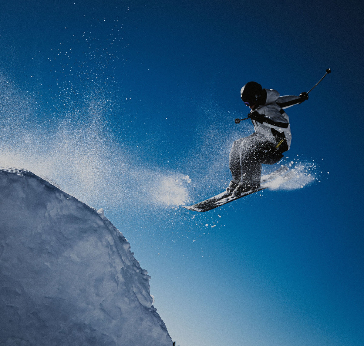 Skier mid-jump against a deep blue sky