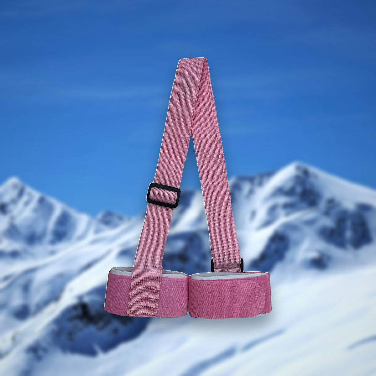 Alpine ski carry strap in pink with two hook-and-loop ski loops, on a snowy mountain backdrop