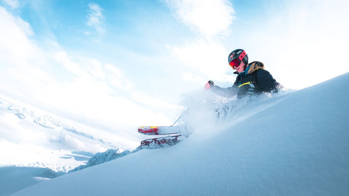 Skier throwing up a wave of powder on a sunny day