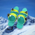 Pair of Alpine Snow Skates mini skis in green with adjustable bindings, on a snowy mountain backdrop