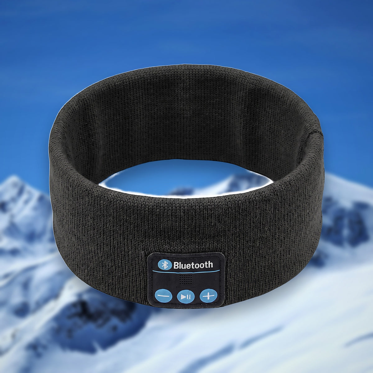 Tunes Band Bluetooth ski headband in black, shown in the round on a snowy mountain backdrop