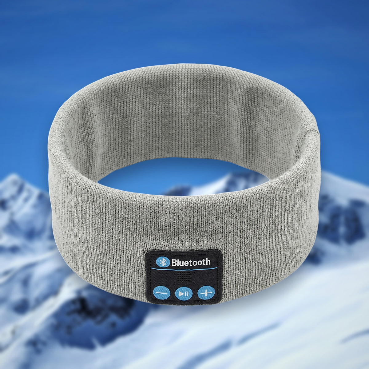 Tunes Band Bluetooth ski headband in light grey, shown in the round on a snowy mountain backdrop